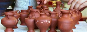 Group of terracotta vessels with handles and white decorations